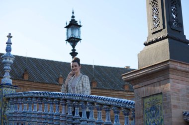 Gündelik giysiler içinde genç ve güzel bir kadın Sevilla 'daki ünlü Plaza de Espana' yı ziyaret ediyor. Kadın eski Avrupa kentini gezmekten zevk alıyor. Tatil ve seyahat kavramı