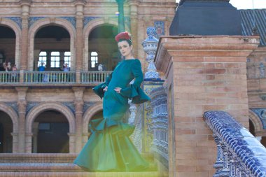 Yeşil fırfırlı elbisesi ve dans eden flamenko 'su olan genç ve güzel kadın Endülüs, Seville' deki Plaza de Espana 'nın merdivenlerinde. Bu kadında sanat var ve tipik bir İspanyol.