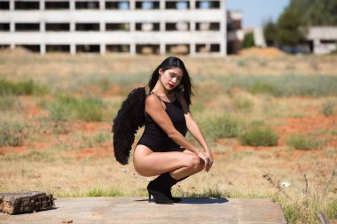 Siyah kanatlı, genç, güzel, siyah saçlı bir Latin kadın savaş ve kıyametin mahvettiği bir şehrin kalıntıları arasında duruyor. Üzüntü ve kederle etrafına bakıyor.