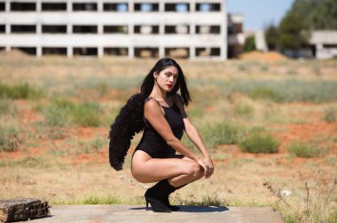 Siyah kanatlı, genç, güzel, siyah saçlı bir Latin kadın savaş ve kıyametin mahvettiği bir şehrin kalıntıları arasında duruyor. Üzüntü ve kederle etrafına bakıyor.