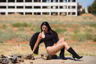 Siyah kanatlı, genç, güzel, siyah saçlı bir Latin kadın savaş ve kıyametin mahvettiği bir şehrin kalıntıları arasında duruyor. Üzüntü ve kederle etrafına bakıyor.