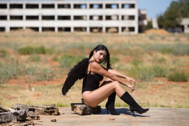 Siyah kanatlı, genç, güzel, siyah saçlı bir Latin kadın savaş ve kıyametin mahvettiği bir şehrin kalıntıları arasında duruyor. Üzüntü ve kederle etrafına bakıyor.