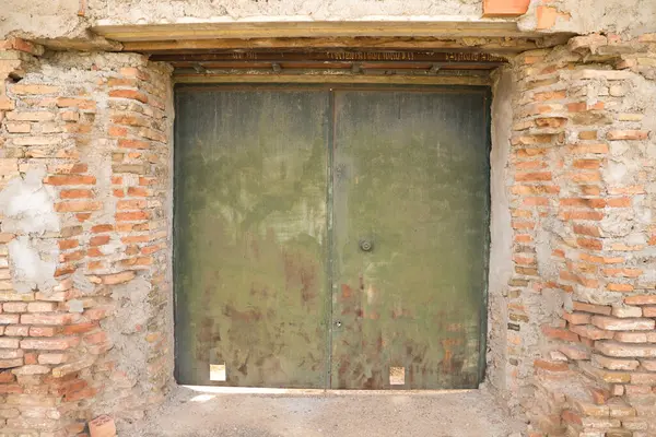 Zamanın geçmesiyle paslanmış ve boyanmamış demir bir kapı.