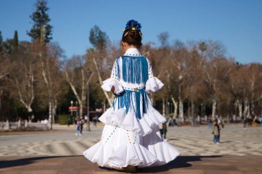 İspanya 'da, Seville' de ünlü bir meydanda beyaz elbise ve fırfırlı mavi püsküller içinde flamenko dansı yapan küçük bir kız. Kızın kafasında çiçekler var. Flamenko, insanlığın kültürel mirası.