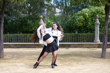 Latin müziği eşliğinde dans eden birkaç genç kadın Bachata, merengue, salsa. İki kız sokakta dans ederken farklı duruşlar sergiliyor. Latin dansları ve dans konsepti