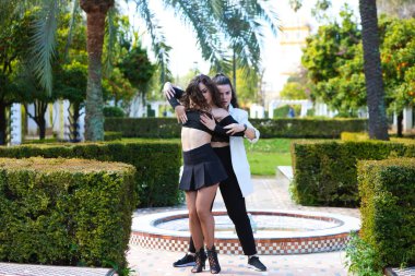 Farklı türde Latin müziği eşliğinde dans eden iki genç kadın. İki kız sokakta dans ederken farklı duruşlar sergiliyor. Latin dansları ve dans konsepti