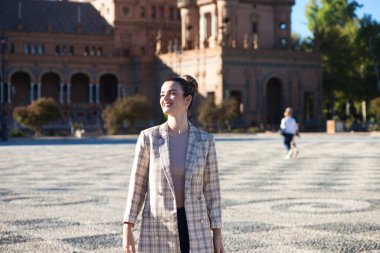 Gündelik giysiler içinde genç ve güzel bir kadın Sevilla 'daki ünlü Plaza de Espana' yı ziyaret ediyor. Kadın eski Avrupa kentini gezmekten zevk alıyor. Tatil ve seyahat kavramı