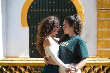 Farklı türde Latin müziği eşliğinde dans eden iki genç kadının portresi. İki kız sokakta dans ederken farklı duruşlar sergiliyor. Latin dansları ve dans konsepti