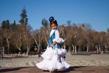 İspanya 'da, Seville' de ünlü bir meydanda beyaz elbise ve fırfırlı mavi püsküller içinde flamenko dansı yapan küçük bir kız. Kızın kafasında çiçekler var. Flamenko, insanlığın kültürel mirası.