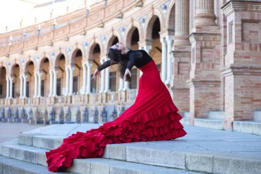İspanya, Seville 'de bir meydanda flamenko dansı yapan güzel bir kadın. Tipik bir kırmızı ve siyah çingene elbisesi giyiyor ve bir sürü sanatla flamenko dansı yapıyor. Elbise meydanın merdivenlerinden sarkıyor.