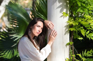 Genç ve güzel Latin kadın, farklı sorunlar yüzünden üzgün, sinirli ve depresif. Beyaz mermer bir sütuna yaslanıyor. Ruh sağlığı hastalığı kavramı