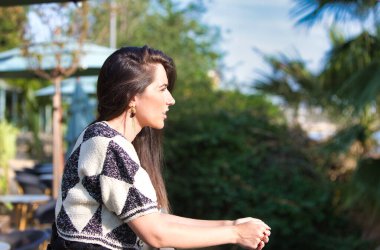 Demir korkuluklara yaslanan genç ve güzel Latin kadın nehri geçerken üzgün ve depresif görünüyor. Kadın dalgın, bitkin ve yorgun görünüyor. Kadın acı çekiyor..