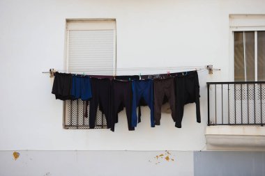 Bir apartman bloğundaki bir apartmanın dışındaki balkonda temiz çamaşır kuyruğu.