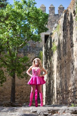 blonde drag queen dressed in pink in a medieval castle poses and makes different postures and expressions in her performance. Concept of equality and lgtbqi+ rights. Gender Identity clipart