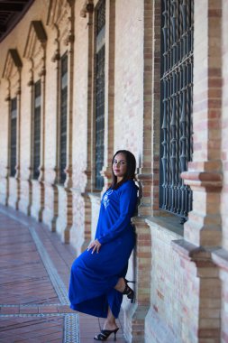 Faslı esmer, genç ve güzel, mavi abaya giyimli, tipik Arap kadın kıyafetleri. Kadın İspanya meydanında Sevilla 'da kemer ve kolonların altında. Seyahat kavramı