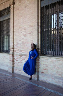 Faslı esmer, genç ve güzel, mavi abaya giyimli, tipik Arap kadın kıyafetleri. Kadın İspanya meydanında Sevilla 'da kemer ve kolonların altında. Seyahat kavramı