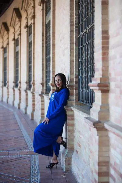 Faslı esmer, genç ve güzel, mavi abaya giyimli, tipik Arap kadın kıyafetleri. Kadın İspanya meydanında Sevilla 'da kemer ve kolonların altında. Seyahat kavramı