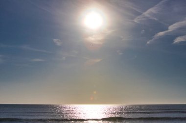 Güneş, İspanya 'nın Cadiz kentindeki Atlantik Okyanusu' nun altın saatinde denize yansıyor. Su üzerinde altın güneş ışığının yansıması. Gün batımında parlak güneş ışığıyla deniz manzarası