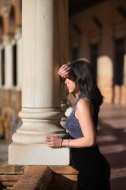 İspanyol kadın, esmer, genç ve güzel elini ve başını Seville, Endülüs 'teki ünlü İspanya meydanındaki mermer sütuna koyar. Kız üzgün ve dalgın görünüyor.