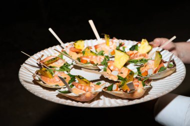 Farklı aromalı kanepeler, balıklar, deniz ürünleri, jambon, et, sebzeler yemek servisine hazır.