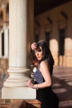 İspanyol kadın, esmer, genç ve güzel elini ve başını Seville, Endülüs 'teki ünlü İspanya meydanındaki mermer sütuna koyar. Kız üzgün ve dalgın görünüyor.