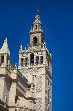 İspanya 'nın Endülüs kentindeki Seville şehrinde Giralda ve Gotik tarzı katedral. Arka planda mavi gökyüzü