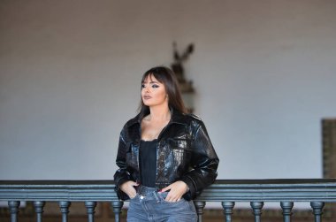 Önüne bakan deri ceketli ve güzel esmer kadının profil portresi.