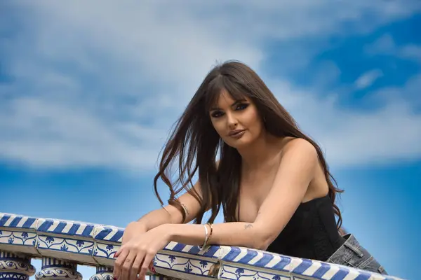 Endülüs, İspanya 'da Seville' de bulunan İspanya meydanındaki bir köprünün fayanslı korkuluklarından dışarı bakar. Mavi gökyüzü ve arkaplanda bulutlar