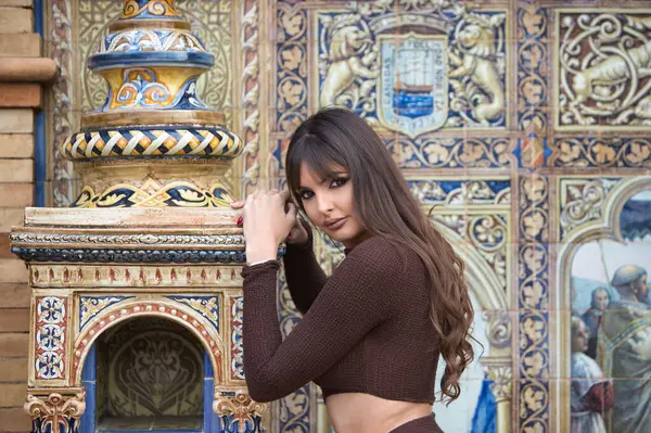 Dudaklarından estetik operasyonlar yapan genç ve güzel bir kadın ve Seville 'deki İspanya meydanındaki fayans tezgahına yaslanan elmacık kemikleri. Kadın mutlu ve gülümsüyor.