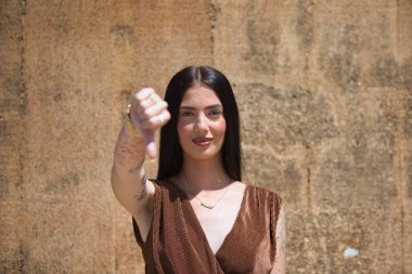Genç Latin bir kadın kameraya bakıyor. Onaylamama ve anlaşmazlık jesti yapıyor.