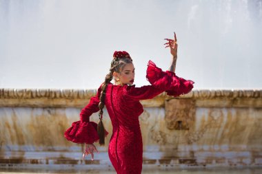 İspanya, Seville 'de bir meydanda flamenko dansı yapan güzel bir kadın. Fırfırlı kırmızı bir elbise giyiyor ve büyük bir sanatla flamenko dansı yapıyor. Flamenko, insanlığın kültürel mirası.