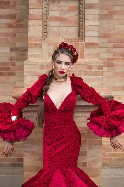 Kırmızı fırfırlı elbisesiyle flamenko yapan güzel bir kadın duvara yaslanmış ve tırnakları aşağıya doğru eğilmiş. Flamenko, insanlığın kültürel mirası.