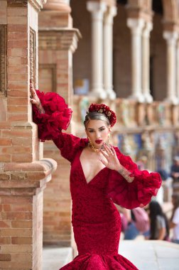 İspanya, Seville 'de bir meydanda, tuğla bir sütuna yaslanmış flamenko dansı yapan güzel bir kadın. O, kırmızı bir fırfırlı elbise giyiyor. Flamenko, insanlığın kültürel mirası.