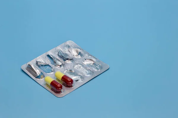 stock image Pills in a black bowl on a blue background. Medical concept