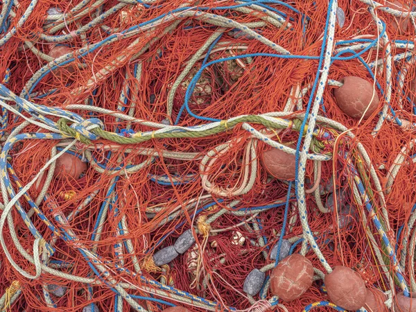 Fishing nets on the pier. Red textured background of fishing nets close-up.