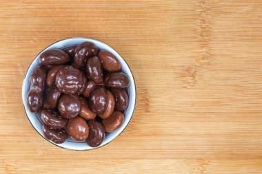 Sinterklaas / St. için çikolata kaplı Hollanda bayramı zencefilli kurabiyeleri. Nicholas seramik bir kasede tahta bir kesme tahtasının üzerinde. Yukarıdan görüntüle.