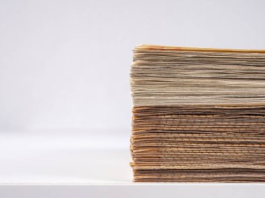 Masanın kenarına yığılmış avroluk banknotlar, makro çekim, hafif bir arkaplan üzerinde.