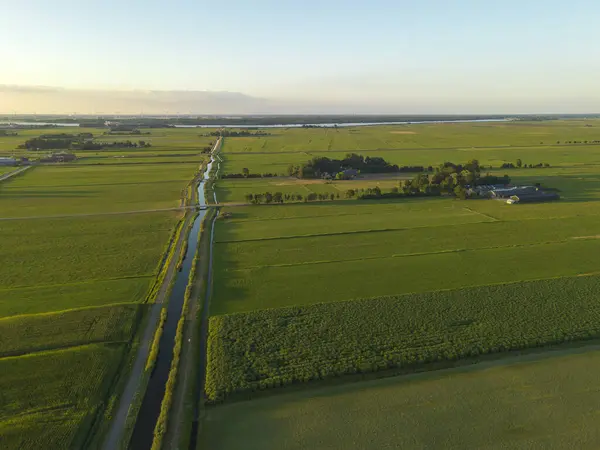 Arka planda tarım alanları, su kanalları ve yel değirmeni parkının yüksek açılı görüntüsü.