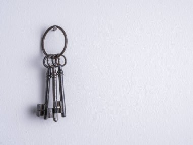 Eski, paslı, demir tuşlar Beyaz duvarda bir yüzük.