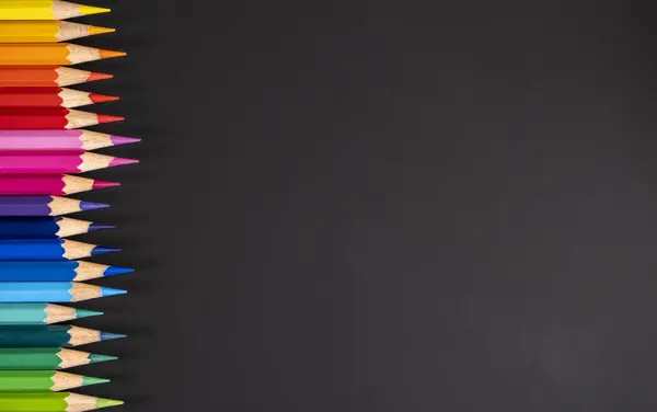 Siyah tahtada solda bir sıra renkli kalem var..