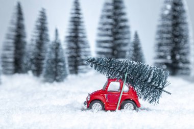 Çatıda Noel ağacı olan kırmızı oyuncak araba. Noel ve Yeni Yıl kavramı.