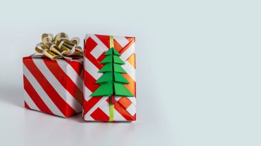 Noel hediyeleri ambalaj kağıdında bir fiyonk ve beyaz arka planda bir köknar ağacı. Boşluğu kopyala.