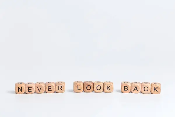 Asla arkana bakma! Tahta bloklar ve beyaz arkaplanda siyah harfler.