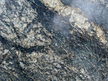 Kırık ve yosunlu doğal bir taş dokusu, pürüzlü ve yıpranmış detayları gösteriyor..