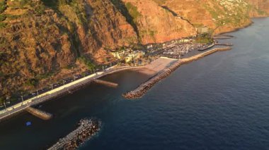 Günbatımında Calheta plajı, marina ve kasaba havadan görünüyor, Madeira