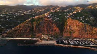 Yüksek uçurumlardaki Calheta kıyı kasabasının havadan panoramik manzarası, liman ve rıhtımdaki plajlar