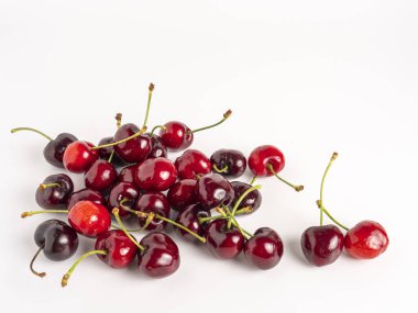 Köklü taze kırmızı ve koyu kirazlar, beyaz arka planda izole..