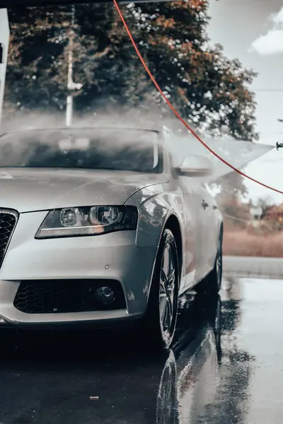 Arabasını yıkayan bir kadın. Arabasıyla ilgilenen genç bir kız..