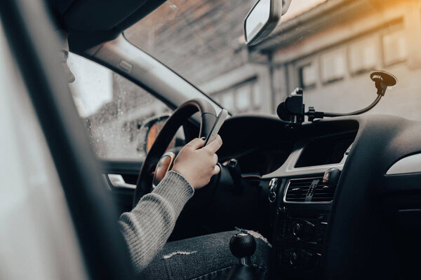 Молодая девушка моет машину. Девушка, сидящая в машине на телефоне.