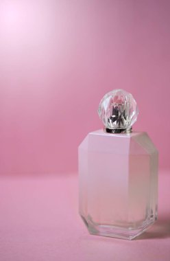 Pembe arka planda pembe bir parfüm. Kadınlar için parfüm. Pembe parfüm.. 